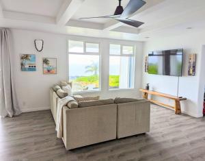 a living room with a couch and a ceiling fan at Maka'Ala Lani - A view of Heaven in Keaau