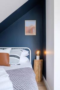 a bedroom with a blue wall with a bed at Scandi Inspired 2 Bed Suite Sandbanks Pass Incl in Picton