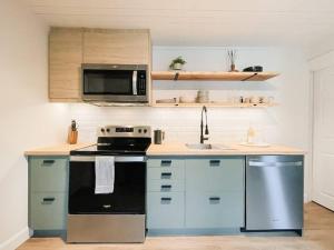 a kitchen with a stove and a microwave at Scandi Inspired 2 Bed Suite Sandbanks Pass Incl in Picton