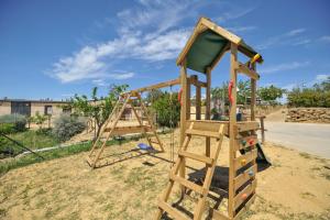 een houten speeltuin met een glijbaan in een tuin bij Luna - Agriturismo-La Fattoria di San Francesco in Pietraperzia