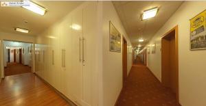 un pasillo de un hospital con paredes blancas y suelos de madera en Hotel Evido Salzburg City Center, en Salzburgo