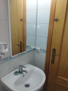 a bathroom with a white sink and a mirror at Adosado con Patio Punta Umbria in Punta Umbría +22 photos