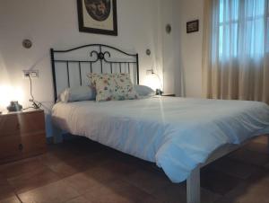 a bedroom with a large white bed with two lamps at Adosado con Patio Punta Umbria in Punta Umbría