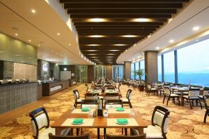 YeojuにあるSun Valley Hotelの木製のテーブルと椅子、大きな窓のあるレストランを併設しています。
