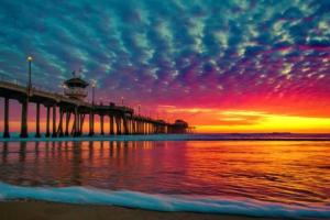 a pier on the beach with a sunset in the background at Lovely & coxy 2BR/2BA! 5MIN to Disney! in Anaheim