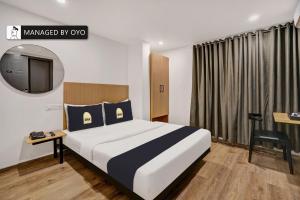 Cette chambre comprend un lit et une télévision. dans l'établissement Super Townhouse Oak A2 Indiranagar 2nd Stage, à Bangalore