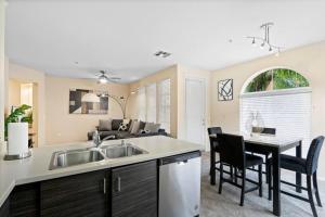 a kitchen with a sink and a table with chairs at Lovely & coxy 2BR/2BA! 5MIN to Disney! in Anaheim