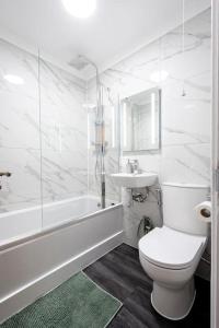 a white bathroom with a toilet and a sink at Paddington House in London