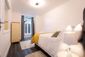 ein weißes Schlafzimmer mit einem Bett und einem Fenster in der Unterkunft Paddington House in London