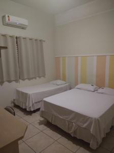 una habitación con dos camas y una ventana en Hotel Dublin, en Araraquara