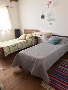 1 dormitorio con 2 camas, escritorio y mesa en Duplex Vivero Miramar Argentina en Miramar