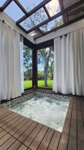 bañera de hidromasaje en una habitación con ventanas en Boho Home - Casa Campestre, Respira Naturaleza!, en Sáchica