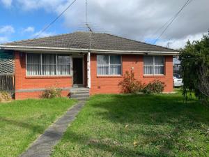 a red brick house with a grass yard at Corio (Geelong) Holiday Villa in Corio