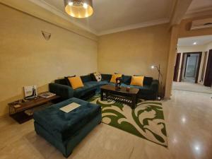 een woonkamer met een bank en een tafel bij Plage, Piscine, et Confort Moderne in Skhirat