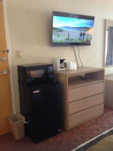 a room with a microwave and a refrigerator and a tv at Sky Suites in Tybee Island