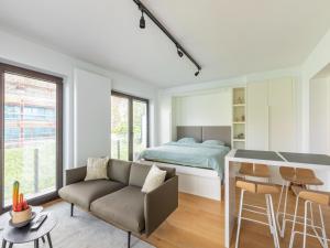 a bedroom with a bed and a couch and a table at Beautiful renovated studio in Zeebrugge on the beach in Zeebrugge