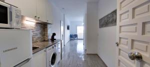 a kitchen with a washer and dryer next to a door at Benal Beach Vibe in Benalmádena