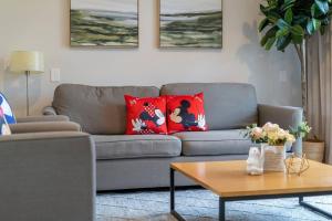 a living room with a gray couch with red pillows at Find your Cozy home 8 minutes near Disney and Universal in Orlando