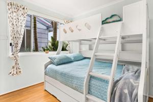um beliche branco num quarto com uma janela em Calm 3922 em Surf Beach