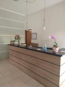 a lobby with a reception counter with flowers on it at Hotel Dublin in Araraquara
