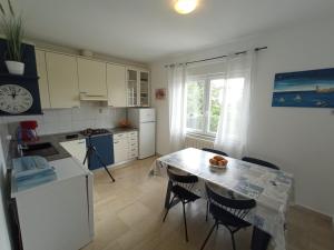 a kitchen with a table and chairs and a table and a kitchen with a counter at Apartman Šimun in Rijeka