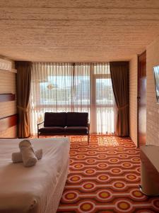 Indian Ocean Hotel في بيرث: غرفة نوم بسرير واريكة في غرفة