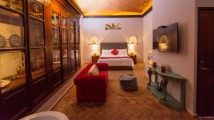 ein Hotelzimmer mit einem Bett und einem roten Sofa in der Unterkunft Casa Eva Hotel Boutique & Spa in Cholula de Rivadavia