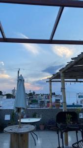 un patio al aire libre con mesa y sombrilla en Casa Verde Hostal en Tlaxcalancingo