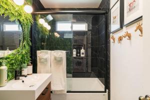 uma casa de banho com um chuveiro e um lavatório branco em * Backyard Oasis + Central Location @ The Wilson * em San Diego