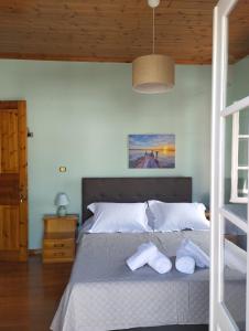 a bedroom with a bed with two towels on it at Othon's Guest House in Hydra