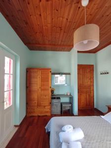 a bedroom with a bed and a wooden ceiling at Othon's Guest House in Hydra