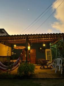 d'une terrasse avec un hamac, une table et des chaises. dans l'établissement Estação Noronha Hostel, à Fernando de Noronha