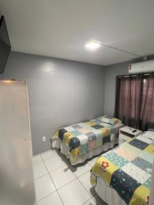 a bedroom with two beds and a window at Apartamento Mobiliado em Petrolina - Recomendado! in Petrolina