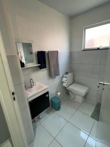 a white bathroom with a sink and a toilet at Apartamento Mobiliado em Petrolina - Recomendado! in Petrolina