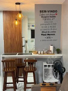 a kitchen with a bar with stools and a counter top at Apartamento Mobiliado em Petrolina - Recomendado! in Petrolina
