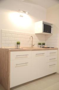 a kitchen with white cabinets and a sink at Bałtyckie-Hel in Hel