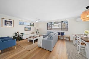 a living room with a couch and a table at Little Palm Cabins in Lake Cathie