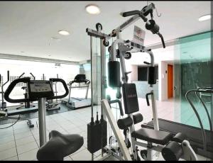 a gym with several tread machines in a room at Flat particular no Hotel Mercure in Brasília