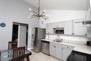 Una cocina con gabinetes blancos y un refrigerador de acero inoxidable. en Luxurious Scottsdale Guesthouse by the Pool, en Phoenix