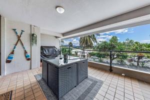 a room with a balcony with a large window at Shelby On Eshelby in Airlie Beach