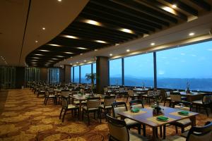 a dining room with tables and chairs and large windows at Sun Valley Hotel in Yeoju