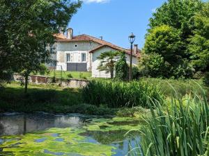 una casa y un estanque frente a una casa en Gîte Montboyer, 4 pièces, 6 personnes - FR-1-653-187 en Montboyer