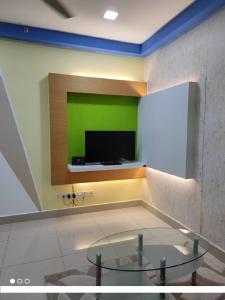 Habitación con una pared verde y TV. en Shaftsbury Residence Cyberjaya with free parking & Netflix en Cyberjaya
