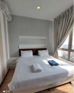 1 dormitorio con 1 cama blanca grande y ventana en Shaftsbury Residence Cyberjaya with free parking & Netflix en Cyberjaya