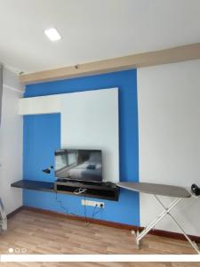 pared de acento azul en una habitación con TV en Shaftsbury Residence Cyberjaya with free parking & Netflix en Cyberjaya