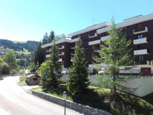 クールシュヴェルにあるAppartement Courchevel 1550, 4 pièces, 7 personnes - FR-1-575-33の道路前の木々のあるアパートビル