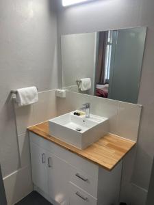 ein Badezimmer mit einem weißen Waschbecken und einem Spiegel in der Unterkunft Lismore Fair Dinkum Motel in Lismore