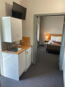 a kitchen with a sink and a bedroom with a bed at Lismore Fair Dinkum Motel in Lismore