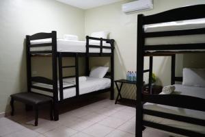 Pokój z 2 łóżkami piętrowymi i krzesłem w obiekcie Mi Tierra Hotel y Restaurante w mieście San Luis