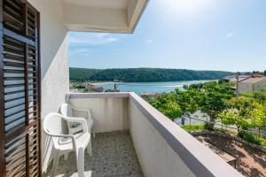 a balcony with two chairs and a view of the water at Apartments Zeljko in Kampor